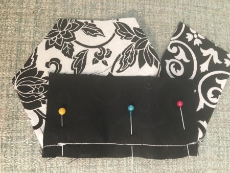 Pinning the next piece of fabric to the quilted piece.