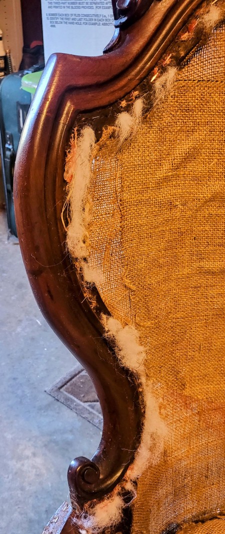 The wooden chair with the upholstery removed.