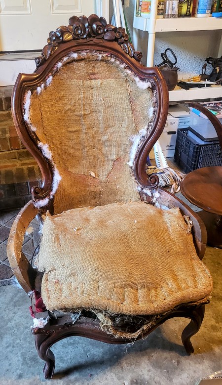 The wooden chair with the upholstery removed.