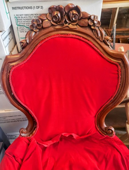 A wooden chair upholstered in red.