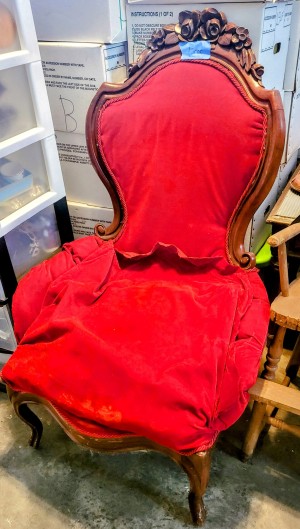 A wooden chair upholstered in red.