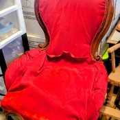 A wooden chair upholstered in red.