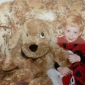 A stuffed dog next to a child.