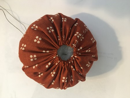 A gathered stuffed pumpkin.