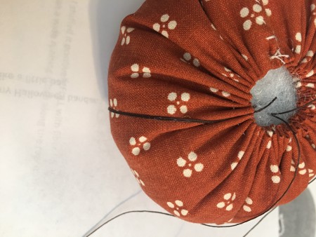 Sewing the pumpkin closed.