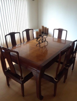 A wooden dining room table with chairs.