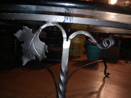 A side view of the metal work on a glass topped table.