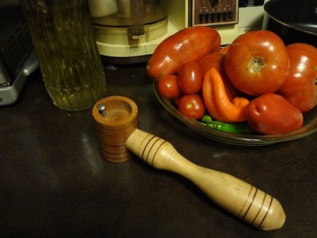 A round wooden tool with a long handle.