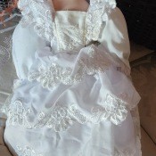 A porcelain doll wearing a white dress.