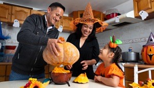 A family carving a pumpkin for Halloween.