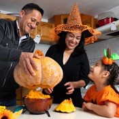 A family carving a pumpkin for Halloween.