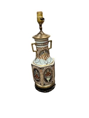 A vase with a lamp on the top.