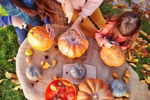 A group carving Jack-'o-lanterns for Halloween.