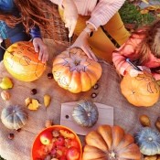 A group carving Jack-'o-lanterns for Halloween.