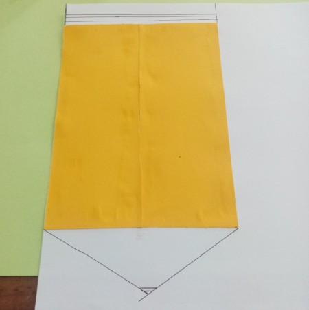 Attaching the yellow paper to a white drawing of a pencil.