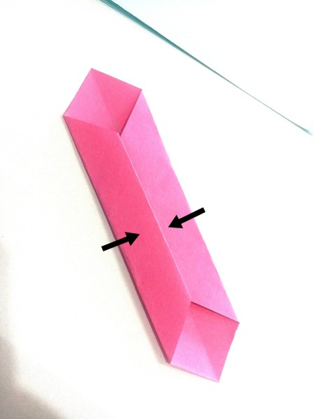 Folding the paper again to be a thin necktie.