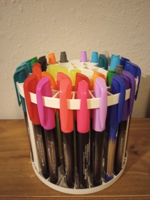 A collection of markers in a round container.