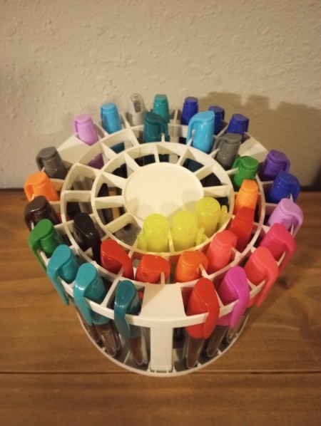 A collection of markers in a round container.