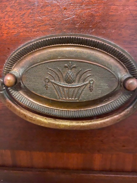 A close up of the metal drawer pull.