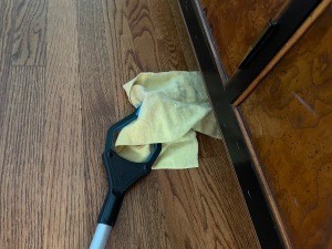 Using a reacher for dusting under furniture.