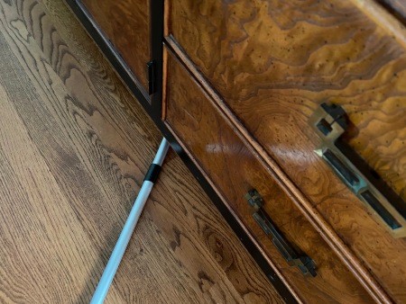 Using a reacher for dusting under furniture.
