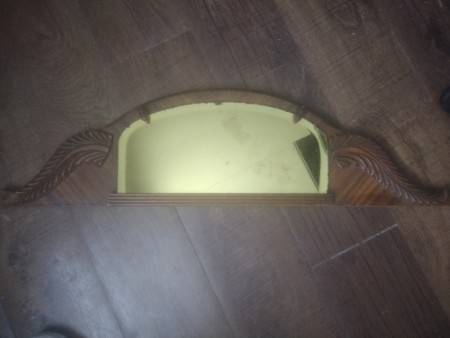A gold tinted mirror to attach to a dresser.