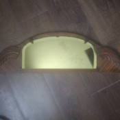 A gold tinted mirror to attach to a dresser.