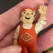A toy figurine of a man in red overalls.