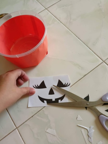 Cutting out Jack-'o-lantern faces.