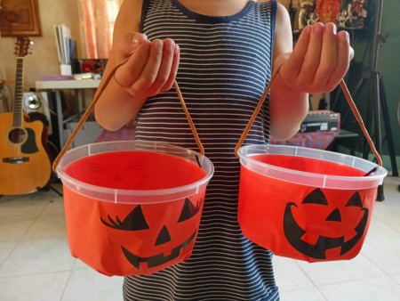 A person holding two decorated buckets.