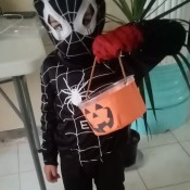 A costumed child holding a bucket.