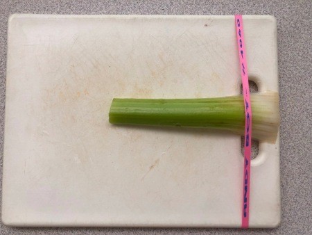 Cutting celery with a cutting board and rubber band.