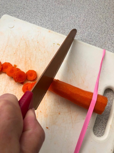 Cutting carrots with a cutting board and rubber band.