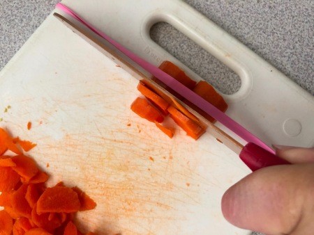Cutting carrots with a cutting board and rubber band.