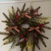 A Christmas wreath decorated with small bows and colorful berries.