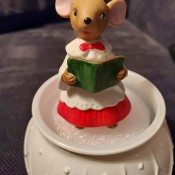 A figurine of a mouse holding a book.