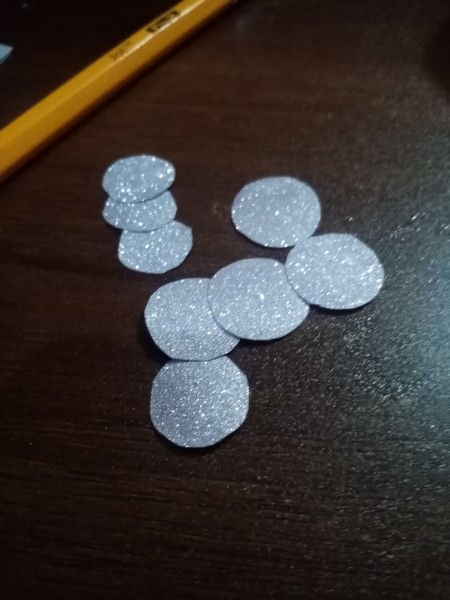 Cutting out small silver dots.