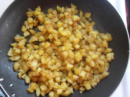 Frying onions with the potatoes.