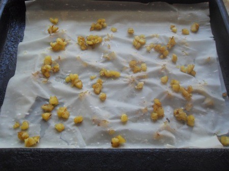 Adding potato to the pastry sheet.