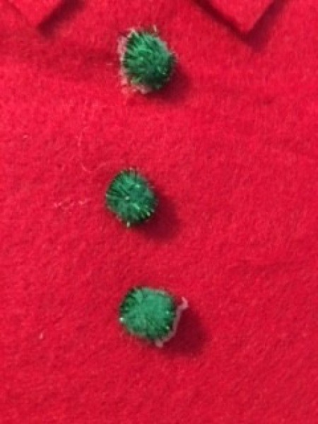 Adding pom poms to the front of the bag.