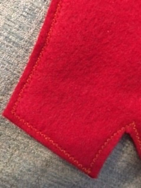 Sewing a seam on the red felt.