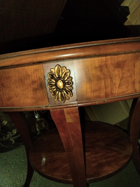 A decorative metal piece on the side of the side table.