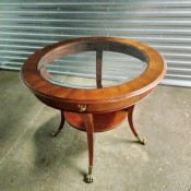 A round side table with a glass top.