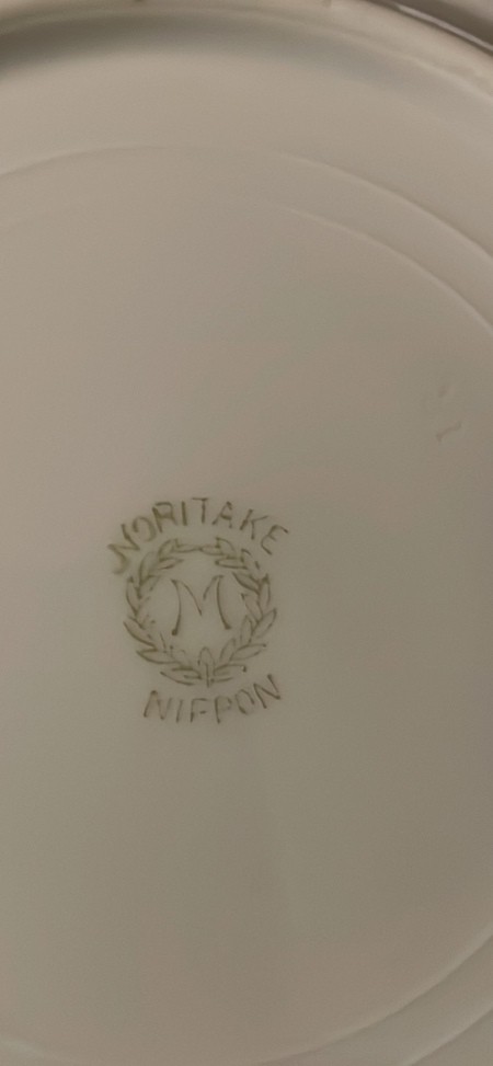 The Noritake logo on the back of the china.