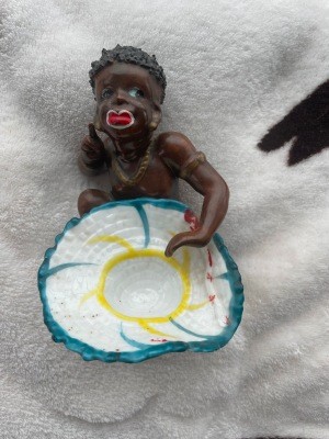 A figurine of a dark skinned native.