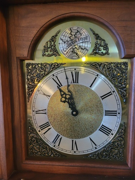 A close up of the face of a grandfather clock.