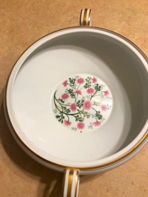 A china sugar bowl with a floral pattern in the bottom.