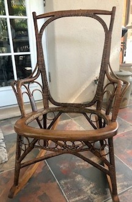 A rocking chair with the rattan missing.