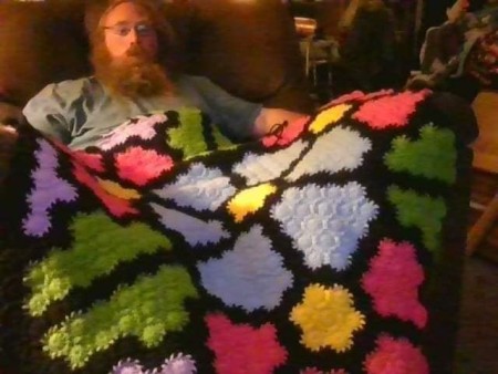 A multi colored crocheted blanket.