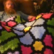 A multi colored crocheted blanket.